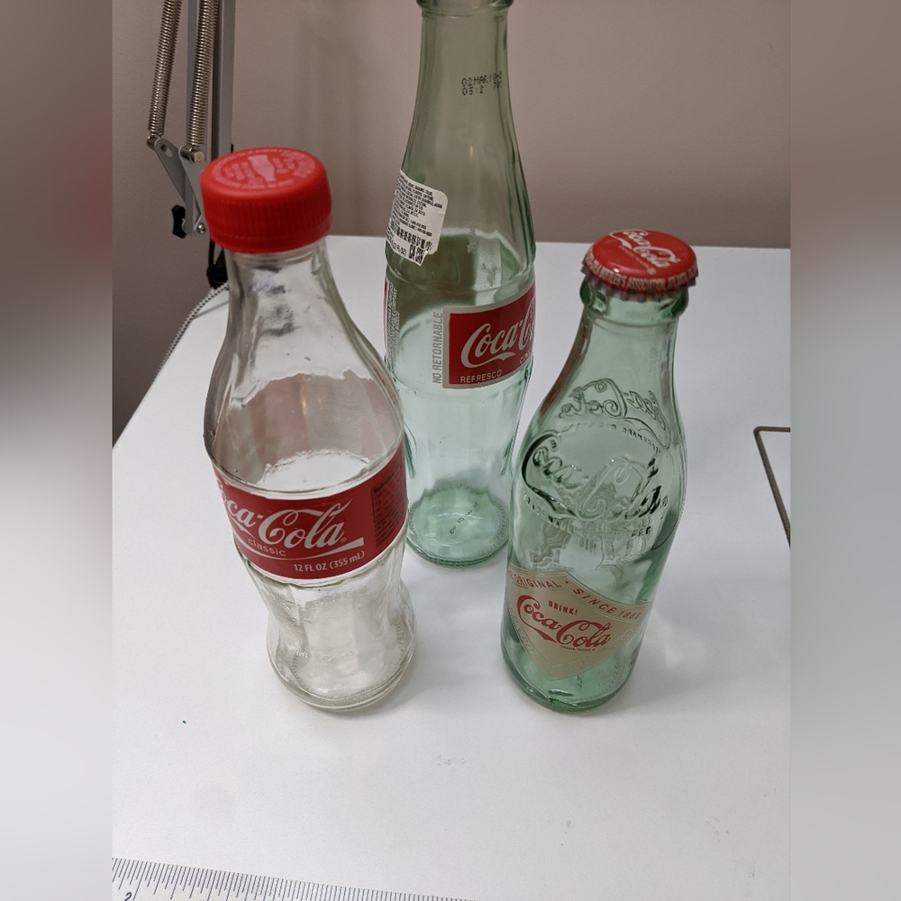 3 glass bottles- Coca cola classic , Coca Cola Atlanta and Coca Cola Refresco